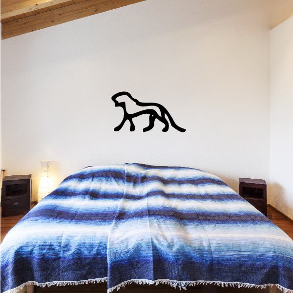 Black animal wall decal with hieroglyphic-style silhouette on a light wall