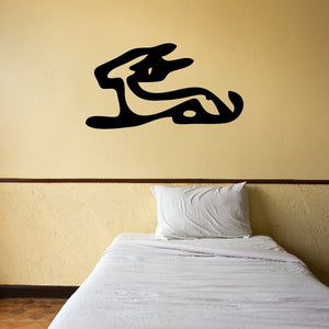 Egyptian hieroglyph wall decal, black stylized symbol on wall above bed