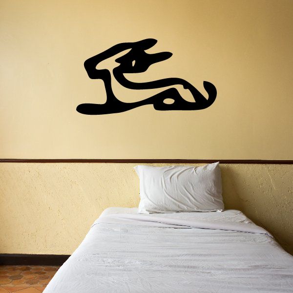 Egyptian hieroglyph wall decal, black stylized symbol on wall above bed