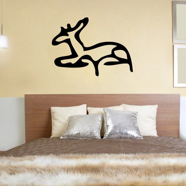 Black Egyptian hieroglyphics wall decal with stylized symbol above a bed