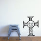 Ornate black cross decal with a smiling face in the center