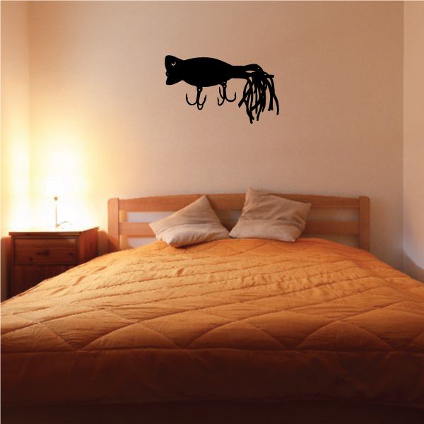 Black fishing lure wall decal with hanging lines above bed