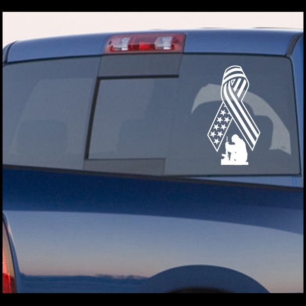 Kneeling soldier flag ribbon car decal, patriotic emblem design in white on dark surface