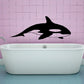 Black killer whale wall decal with fins and tail, floating above a bathtub