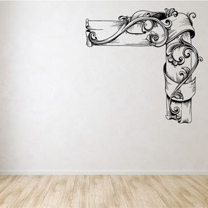 Ornamental vinyl wall decal with floral scroll corner design, arched ribbon and leaves