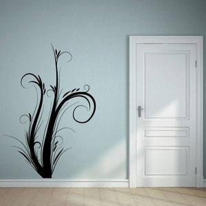 Floral swirl wall decal with black curling leaves and flowers near a white door.