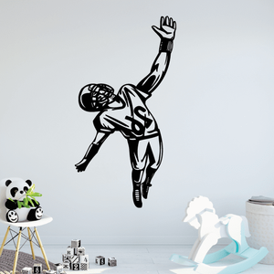 Black football player wall decal with ball held under one arm, arm raised.