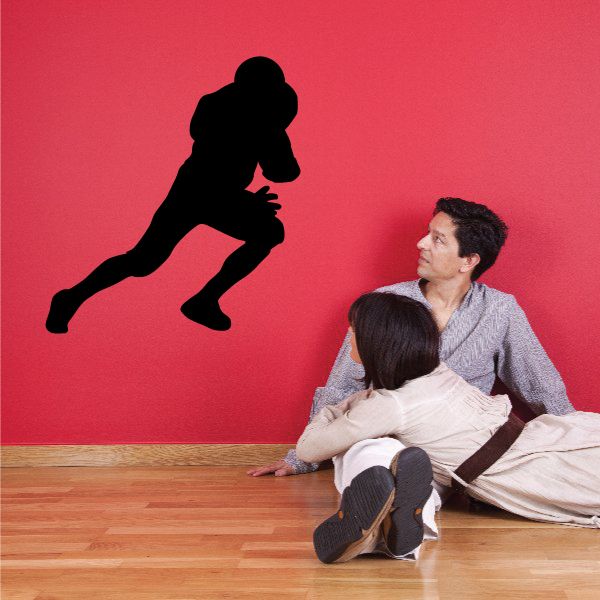 Football player wall decal in black vinyl, silhouette of athlete in kicking pose