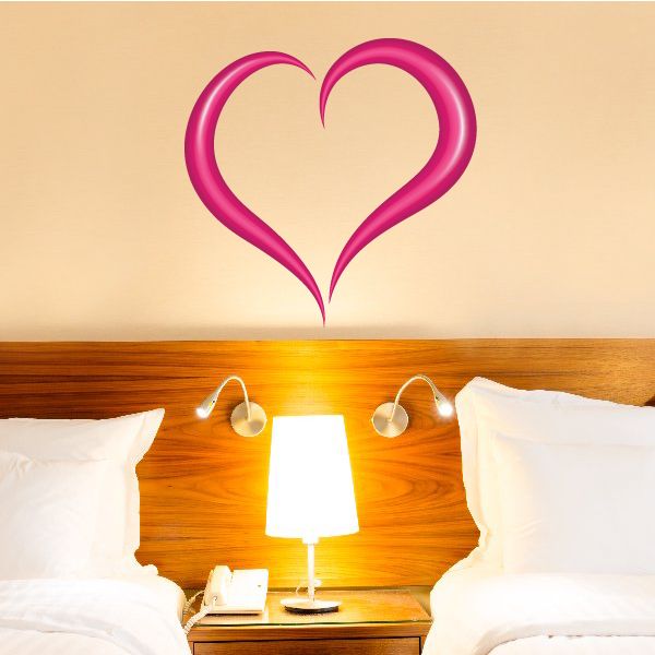 Heart-shaped Valentine wall decal with magenta pink outline above bed