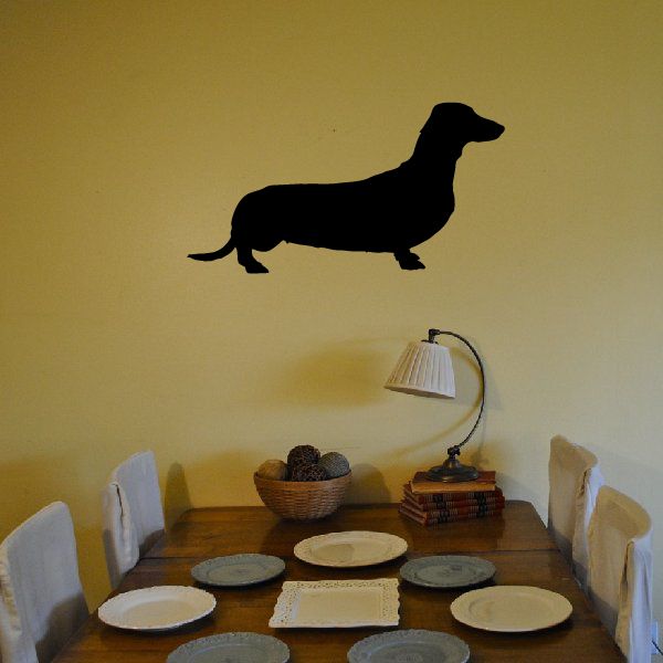 Black dachshund silhouette decal with long body and curled tail
