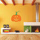 Orange jack-o-lantern wall decal with green stem and carved face, die-cut Halloween design