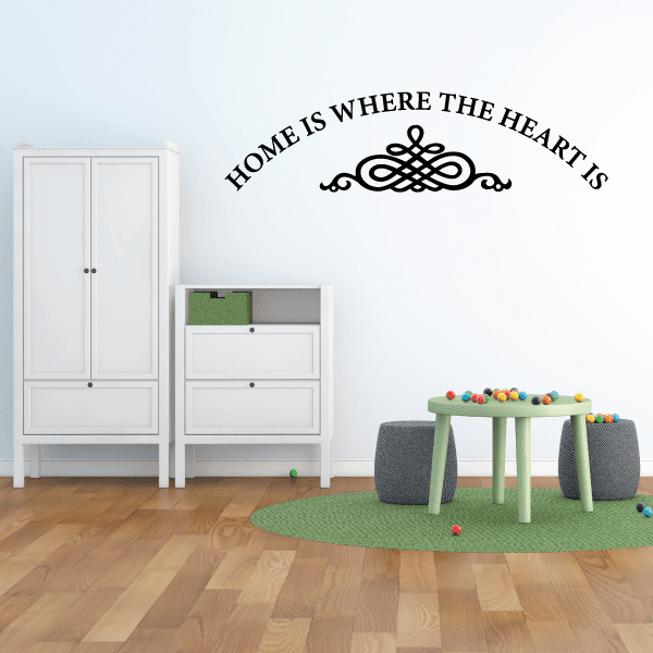 Wall decal in black cursive: 'HOME IS WHERE THE HEART IS' with heart flourish