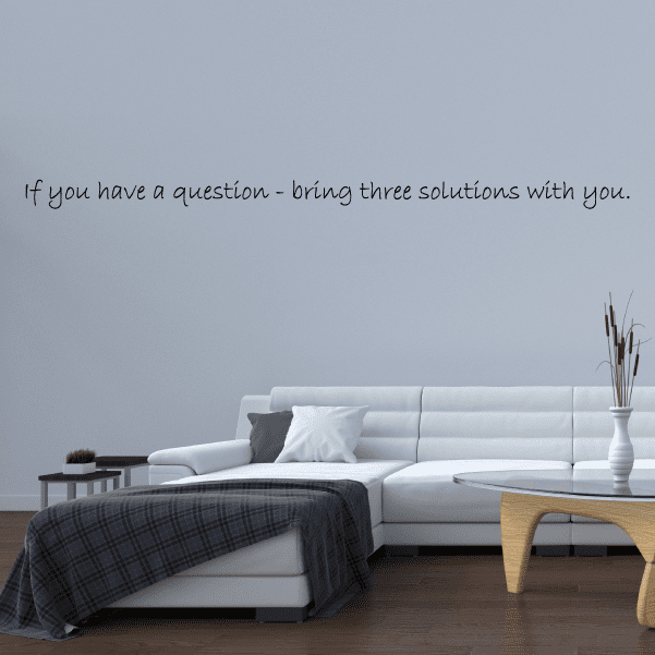 Wall decal with cursive text: “If you have a question bring three solutions with you.”