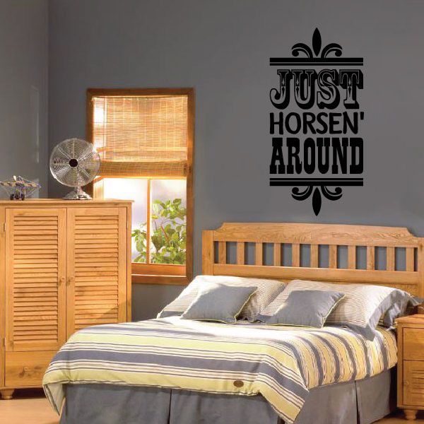 Black vinyl wall quote decal with text "Just Horsen Around" above bed