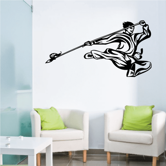 Black karate wall decal sticker of a fighter holding a weapon in a forward kick pose