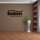 Black wall decal reading “Kindness begets kindness.” with curved underline.