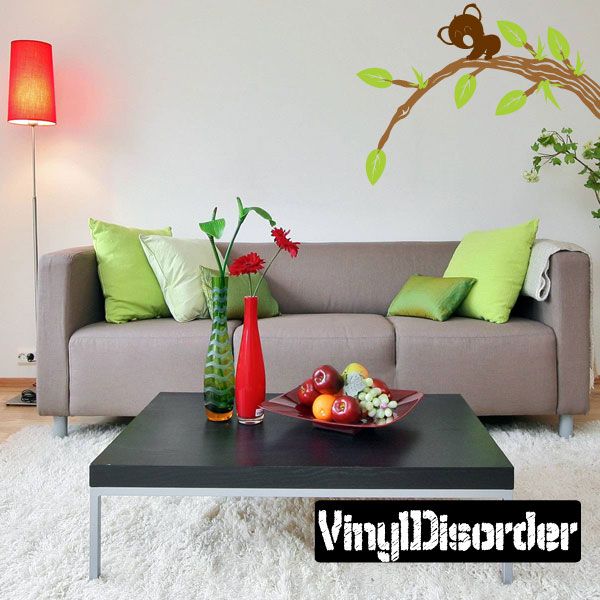 Wall decal of a bear perched on a tree branch with green leaves