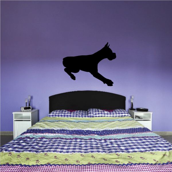 Black jumping dog decal silhouette, landing pose on a wall