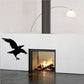 Black crow silhouette decal on wall beside fireplace opening