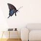 Butterfly wall decal with blue and dark wing details and curled antennae.