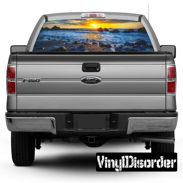 Rear window graphic panel with ocean waves and sunset landscape on a dark truck