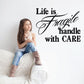 Wall decal text: "Life is fragile" with "Handle with CARE" in black
