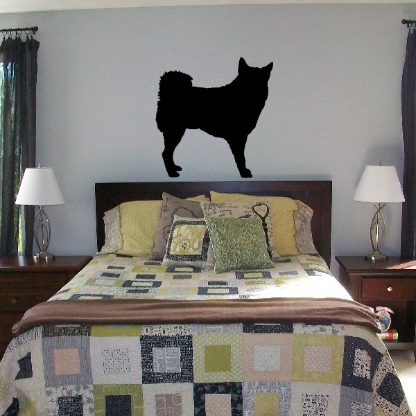 Black dog decal silhouette on wall above bed
