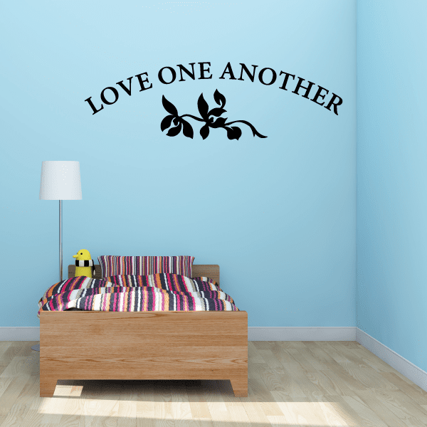 Wall decal with “LOVE ONE ANOTHER” lettering and black vine with flowers