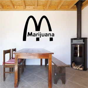 Marijuana M decal with black logo and bold text on a light wall