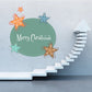 Christmas sticker: teal circle with 'Merry Christmas' and colorful star decorations