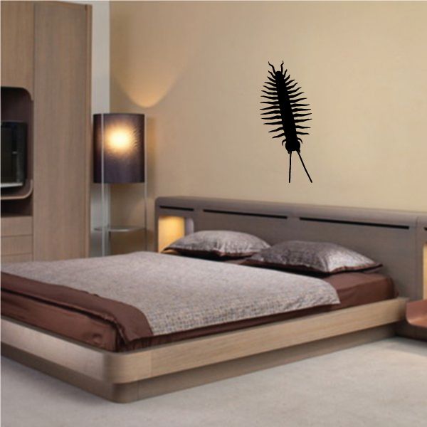 Black millipede crawling decal with straight body on wall