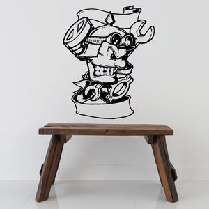 Motorcycle mechanic decal with piston and wrench, black outline on light surface