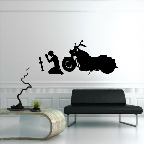 Black wall decal of a praying motorcycle rider kneeling beside a bike