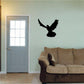 Black dove in flight wall decal with spread wings and downward tail feathers