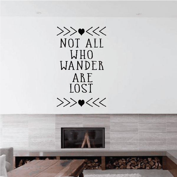 Wall decal reading 'Not all who wander are lost' with arrows and heart