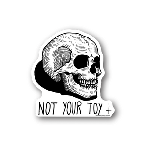 Skull vinyl sticker with bold "NOT YOUR TOY" text; white and black