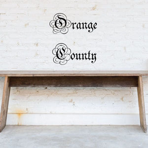 Ornate wall decal with black “Orange County” script letters