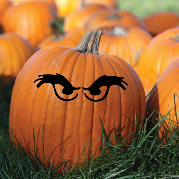 Black stylized eye decals on a pumpkin, arched closed-eye pair