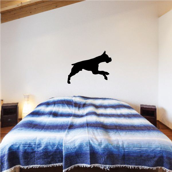 Boxer dog decal with black silhouette jumping on wall above bed