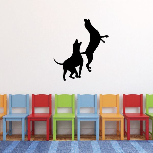Playing dogs vinyl decal with two black dog silhouettes jumping and running