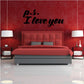 Wall decal with black “p.s. I love you” lettering on a red wall