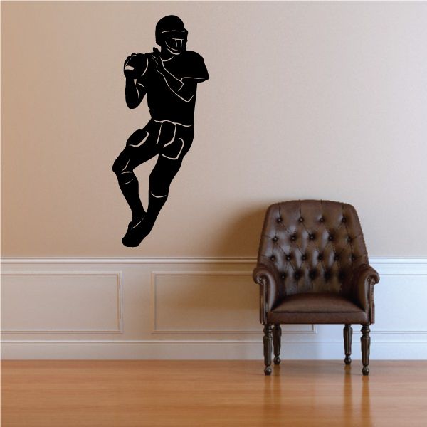 Quarterback football player wall decal, black running pose with helmet and ball.