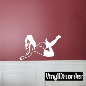White wall decal of a seated woman in socks with legs extended