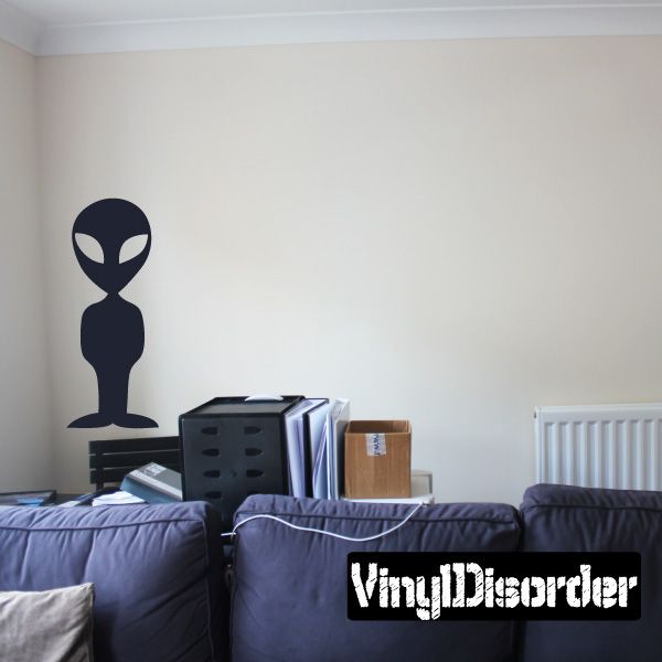 Alien standing wall decal, dark blue silhouette with oval head and antenna.