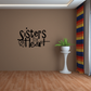 Sisters by heart wall decal with stacked text and small heart icon
