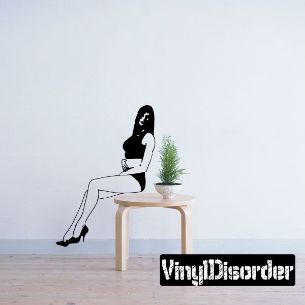 Seated woman short-shorts decal: black silhouette sitting on a small stool with plant
