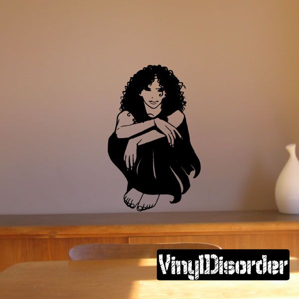 Seated woman decal with curly hair, hugging knees in black silhouette