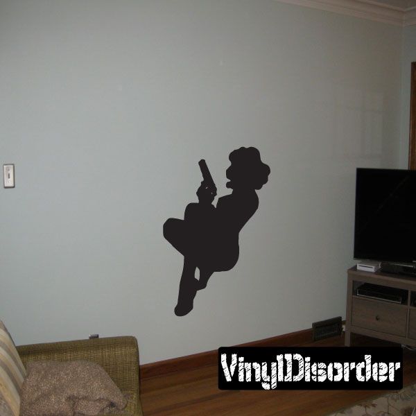 Black silhouette wall decal of a sitting woman holding a gun