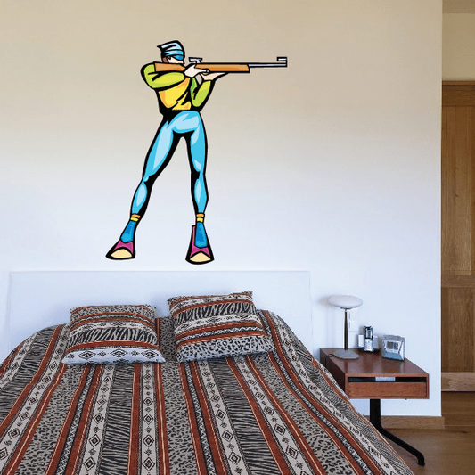 Cartoon skiing wall decal sticker of skier in yellow top and blue pants holding skis