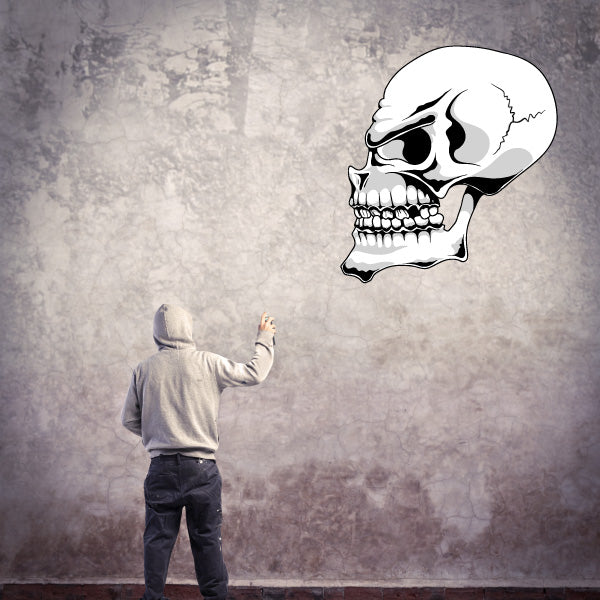 Person gesturing towards a decorative skull decal on the wall